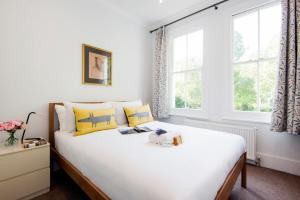 ロンドンにあるThe Stunning Philbeach Garden Apartmentのベッドルーム1室(大型ベッド1台、黄色と青の枕付)
