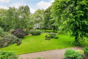 ロンドンにあるThe Stunning Philbeach Garden Apartmentのベンチや木々のある庭園の上空の景色