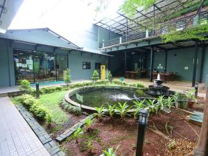 a building with a fountain in the middle of a courtyard at Super OYO Townhouse OAK Hotel Fiducia Pondok Gede in Jakarta