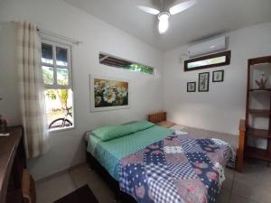 a bedroom with a bed and a window at Floripa Beach House Hostel in Florianópolis