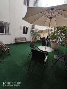 a patio with a table and chairs and an umbrella at Hotel Serrano in Frederico Westphalen