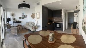 ein Wohnzimmer mit einem Esstisch und einer Küche in der Unterkunft Appartement de luxe Eze village vue mer avec piscine in Èze