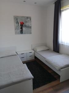une chambre avec deux lits et une personne avec un parasol dans l'établissement House Relic, à Veli Iž