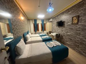 a hotel room with three beds and a tv at MEVLANA ŞEMS HOTEL in Konya