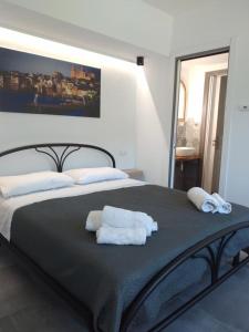 a bedroom with a large bed with towels on it at Holiday Apartment Villa Camilla in Cefalù