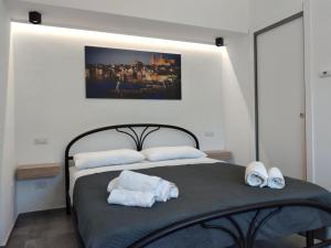 a bedroom with a bed with two towels on it at Holiday Apartment Villa Camilla in Cefalù +30 photos