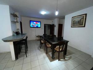 comedor con mesa, sillas y TV en Family apartment near Malecon and Murcielago beach, en Manta