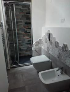 a bathroom with a toilet and a sink and a shower at Holiday Apartment Villa Camilla in Cefalù