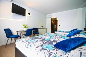 a bedroom with a bed with blue pillows and a table at Motel Na Zbójeckiej in Skawa