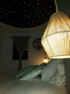 a bedroom with a bed with pillows and a lamp at Au Spa d'eau pâle in Ferques