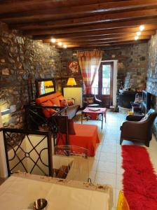 sala de estar con cama roja y pared de piedra en Luxury Residence Jenny, en Palaios Agios Athanasios
