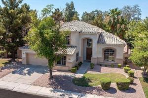 uma casa com uma árvore em frente em Desert LUXURY! 6 bdrm, 3 bath & HEATED pool (SLEEPS 16) em Chandler