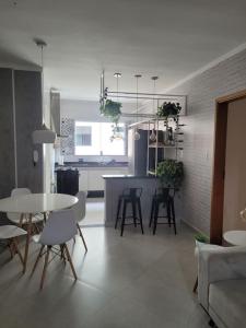 a living room and kitchen with a table and chairs at Apto 1o andar novo 2 Dorm - próximo ao centro in Poços de Caldas