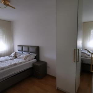 ein Schlafzimmer mit einem Bett und einer Tür zu einem Zimmer in der Unterkunft Alex LUX in Banja Luka