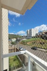 a balcony with a view of a parking lot at Apto 1o andar novo 2 Dorm - próximo ao centro in Poços de Caldas
