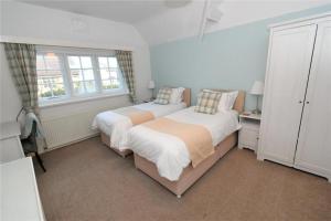 een slaapkamer met 2 bedden en een raam bij Seaways Cottage Hoylake in Hoylake