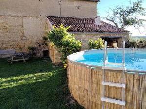 a swimming pool in a yard next to a house at Le Nid du Hibou in Saint-Julien-de-Civry