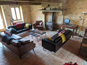 a living room with leather furniture and a fireplace at Le Nid du Hibou in Saint-Julien-de-Civry