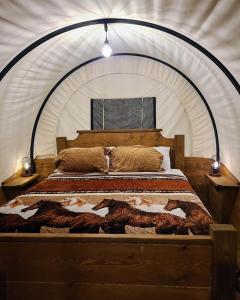 sypialnia z kocem na łóżku w obiekcie Smoky Hollow Outdoor Resort Covered Wagon w mieście Sevierville