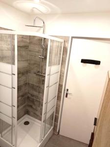 a shower with a glass door in a bathroom at Maison avec extérieur et arrivée autonome - Aurillac in Aurillac