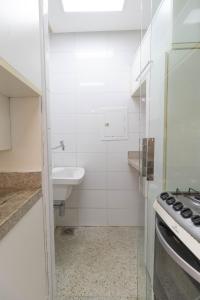 a small white kitchen with a sink and a stove at Apartamento completo próximo de tudo! in Belém