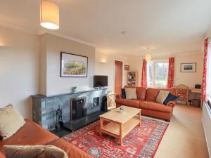 a living room with a couch and a fireplace at Crag View in Underbarrow