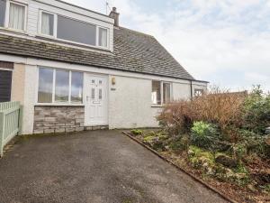 a house with a white door and a driveway at Crag View in Underbarrow