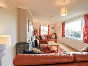 a living room with a leather couch and a fireplace at Crag View in Underbarrow