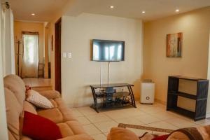 a living room with a couch and a flat screen tv at Villa La Vista of Panama City and magestical mountains from infinity pool in Cerro Azul