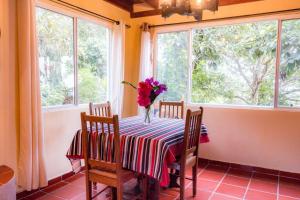 een eettafel met een vaas met bloemen erop bij Villa La Vista of Panama City and magestical mountains from infinity pool in Cerro Azul