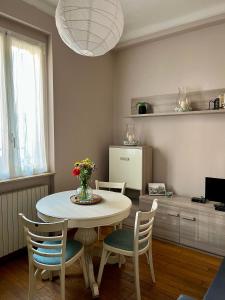 uma mesa de jantar com cadeiras e um vaso de flores em Gionas - Casa indipendente in zona strategica em Milão