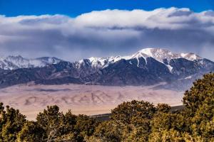 uma serra coberta de neve com árvores em primeiro plano em Holiday Inn Express & Suites Alamosa, an IHG Hotel em Alamosa