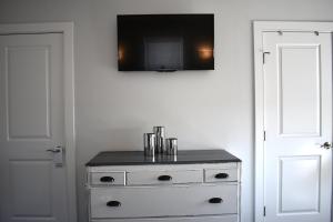 biała komoda z telewizorem na ścianie w obiekcie Grand Victorian an ICONA Boutique Collection w mieście Spring Lake