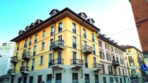 un edificio amarillo con balcones en un lateral en TO-Housing3, luce e relax al centro di Torino en Turín