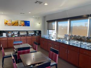 a restaurant with tables and chairs and a counter at Comfort Suites Lake Charles in Lake Charles