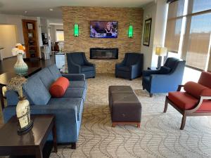 sala de estar con sofá, sillas y TV en Comfort Suites Lake Charles, en Lake Charles