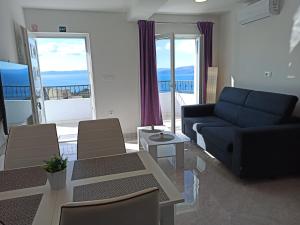 a living room with a couch and a table with chairs at Villa TOP HILL with Private Pool in Makarska
