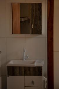 y baño con lavabo y espejo. en Chalé Namastê Pinheira 1, en Palhoça