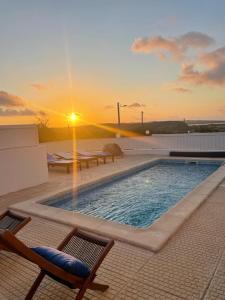 - une piscine au-dessus d'un immeuble avec un coucher de soleil dans l'établissement West Soul Village, à Arelho