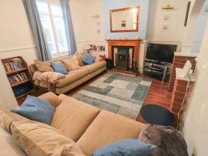a living room with two couches and a television at Smoked Kipper Cottage in Whitby