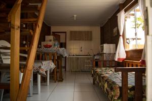 cocina con escalera y mesa en una habitación en Chale Namaste 2, en Palhoça