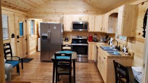 セバービルにあるSmoky Hollow Outdoor Resort - Log Cabinのキッチン(ステンレス製の冷蔵庫、木製キャビネット付)