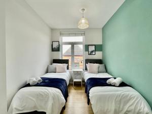 3 camas en una habitación con paredes verdes y blancas en City Centre Gem in Southend near the beach, station and parking, en Southend-on-Sea