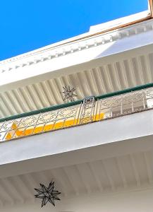 a building with a balcony with a yellow and white railing at Riad Lauriers Blancs in Marrakesh