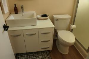 a bathroom with a toilet and a sink at Cozy Family Home - 20 Mins from Disneyland in Placentia
