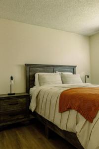 a bedroom with a bed with a wooden headboard and a table at Cozy Family Home - 20 Mins from Disneyland in Placentia