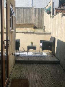 trzy krzesła i stół na patio w obiekcie Stylish property, off street parking,pet friendly w mieście Bath