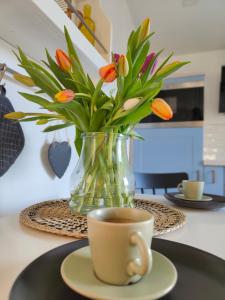 Ferienhaus im Wesenitztal في ستولبين: مزهرية من الزهور وكوب من القهوة على طاولة