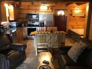 a living room with a kitchen and a table in a cabin at Dollywood-Brand New Dancing Bear 4 in Pigeon Forge