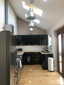 a kitchen with black cabinets and a washer and dryer at Stylish property, off street parking,pet friendly in Bath